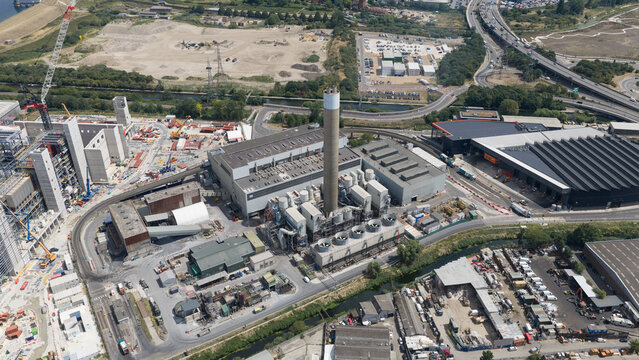 Aerial view of the Edmonton Solid Waste Incineration Plant with its tall chimney, industrial buildings, cooling fans, and surrounding construction site in London, England, United Kingdom.