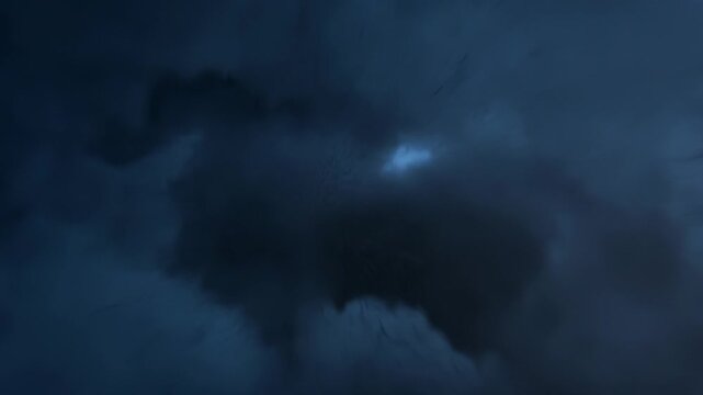 Dark blue thunderclouds, lightning flashes and powerful rapid wind motion inside the epicenter of a storm, dangerous anomalous weather.