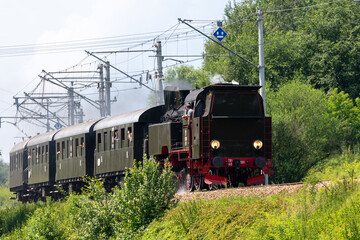 Historic TKt48 steam locomotive pulling a retro passenger train on the railway tracks near Chabowka, Poland © lumofoto