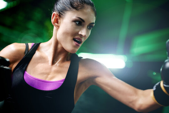 Boxing, punching and gloves with woman in gym for kickboxing exercise, fitness or self defense. Martial arts, fight training and combat with person in ring for workout, boxer and intense sport