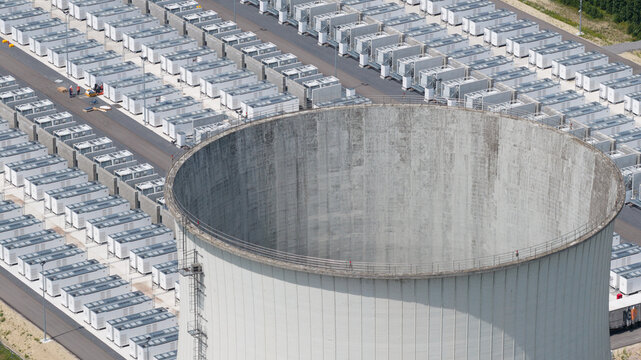 Aerial view of the large cooling tower at the battery energy storage system site, surrounded by rows of white battery containers in Vilvoorde, Vlaanderen, Belgium.