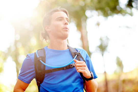 Outdoor, man and exercise with running for fitness, breathing and runner with training for marathon. Nature, male person and athlete with drinking tube for wellness, endurance and cardio for workout