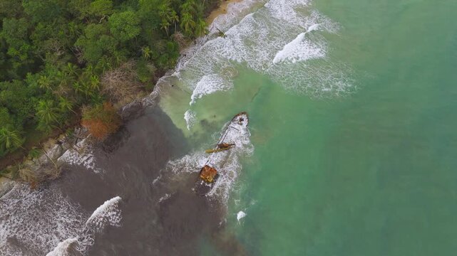 Drone shot of Yicel shipwreck. Huge waves crash around vessel. Lone fisherman throws net. Costa Rica.Playa Grande in Manzanillo