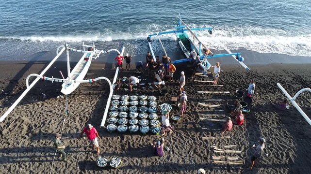 Fishermen return in the morning with their outrigger boats to the black beach of Amed, with Mount Agung in the background, Amed Bali, Indonesia