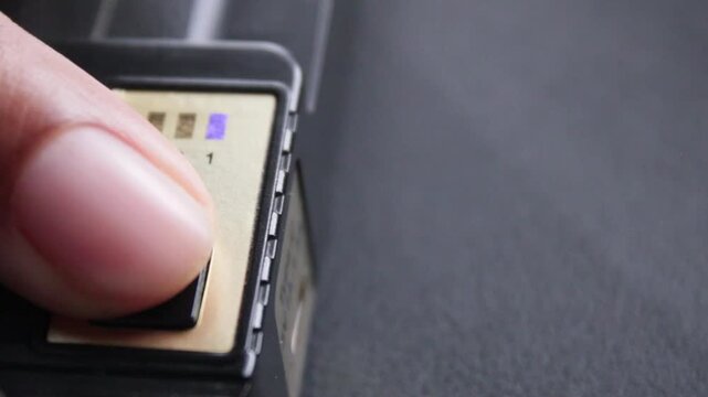 Finger pressing the power button to turn on a tech device close-up
