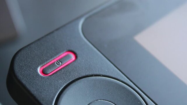 Hand finger pressing power button to start a tech device close up