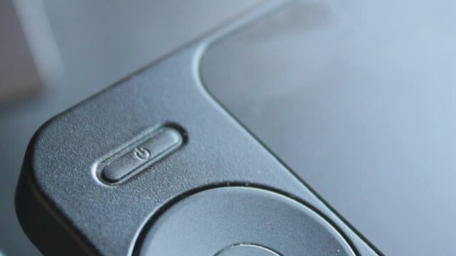 Hand finger pressing power button off on a tech device close up