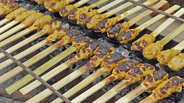 Traditional Balinese minced meat saty lilit grilled on bamboo skewers over charcoal