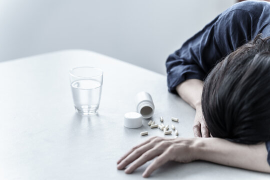 薬を飲んで倒れる女性