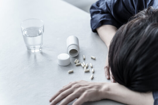 薬を飲んで倒れる女性