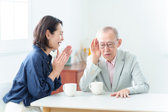 難聴の高齢者に大声で話をする女性