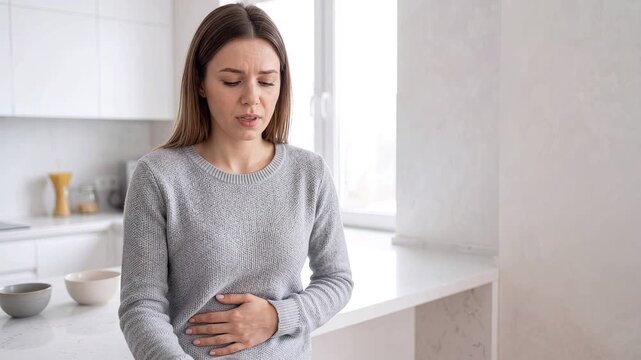 Woman Holding Glass of Milk Experiencing Stomach Ache and Lactose Intolerance