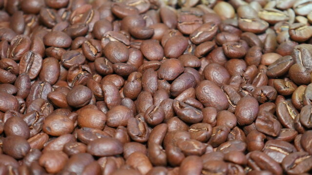 Close up macro shot of freshly roasted brown coffee beans texture background