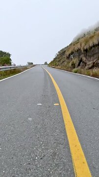Winding Mountain Highway through Misty Highlands Seen from a Moving Car. Vehicle POV. Vertical Video.