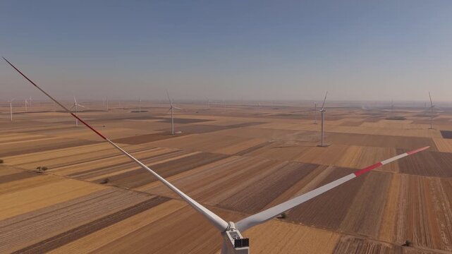 Drone Orbit Around Wind Turbine Rotor Over Golden Farmland