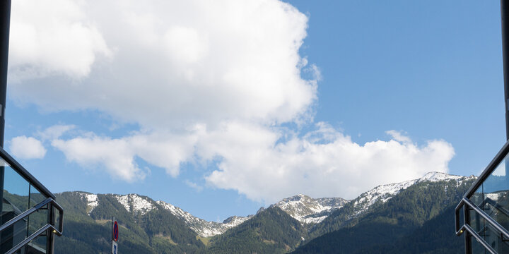 Snow-dusted mountain valley beneath dramatic clouds