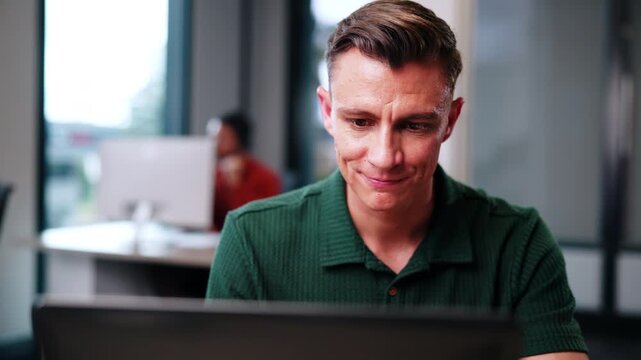 Man, realtor and smile in office with computer, viewing booking and update property listing on website. Estate agent, PC and coworking in firm with reading or auction opportunity for extra commission