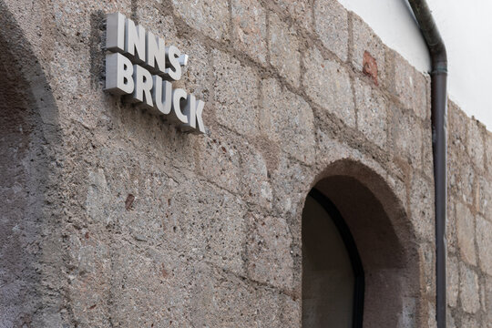 Historic stone wall with Innsbruck sign and arched doorway