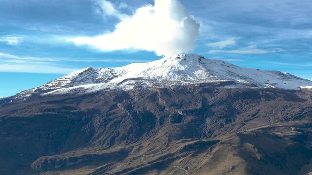 Nevado del Ruiz Snowy Volcanic Summit Rising above Rugged Andean Terrain. Establishing Shot. Aerial View.