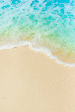 soft foam of turquoise wave on sandy beach, seascape as background