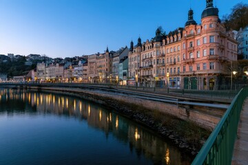 Fototapeta premium Row of historic buildings along a river at dusk