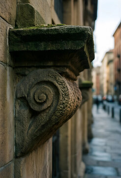 Architectural heritage and urban history, stone corbel detail on an old building facade in a historic city street with blurred background perspective