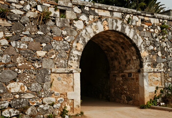 Fototapeta premium Heritage preservation and historical architecture, ancient stone archway entrance in a weathered fortress wall with rustic masonry and textured rock facade