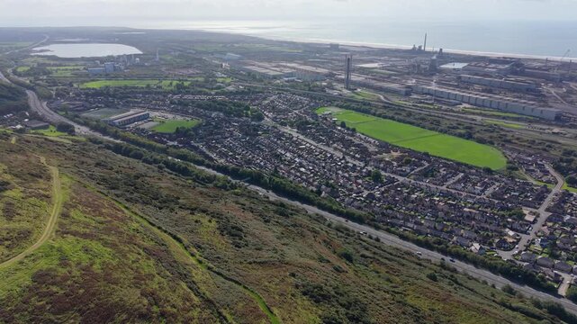 Aerial View of M4 Motorway near Port Talbot with Rows of Compact Houses with Industrial Steelworks Towards Sea.