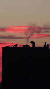 Chimneys of a multi-family residential building emitting black smoke from gas heating.