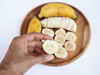 Sliced ​​ripe bananas arranged on a wooden tray—a healthy Thai fruit. © Lookjeabka