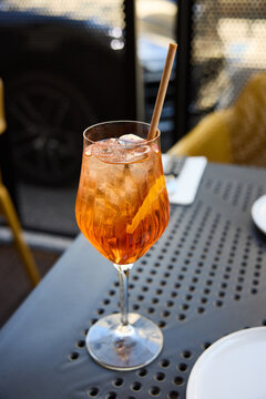 Refreshing Aperol Spritz Cocktail with Orange Slice and Ice on an Outdoor Terrace Table