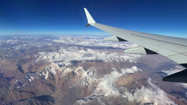 Airplane Wing over Brown Ridges and Patchy Snow in the Hindu Kush