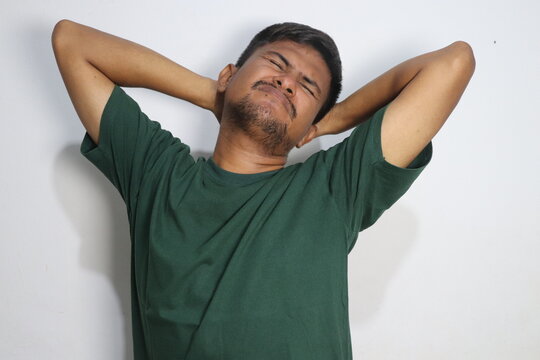 Young man holding his hands behind his head in exhaustion