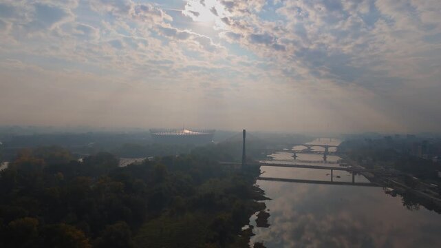 Aerial Drone Footage of Warsaw Cityscape at Sunrise featuring National Stadium, Bridges, and Vistula River