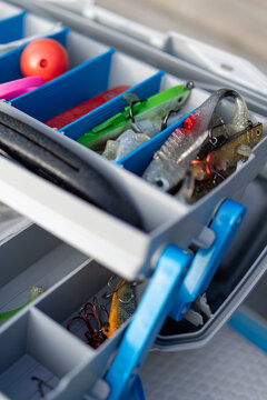 Colorful fishing lures organized in a plastic tackle box