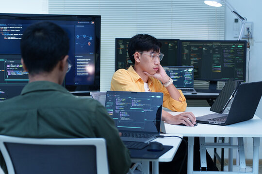 Two young software developers coding in their office