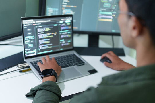 Over the shoulder view of a developer coding on a laptop