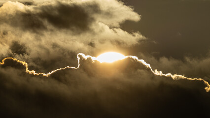 Dramatic sunset sky background with the glowing sun and drifting clouds in vibrant, surreal colors © lumofoto