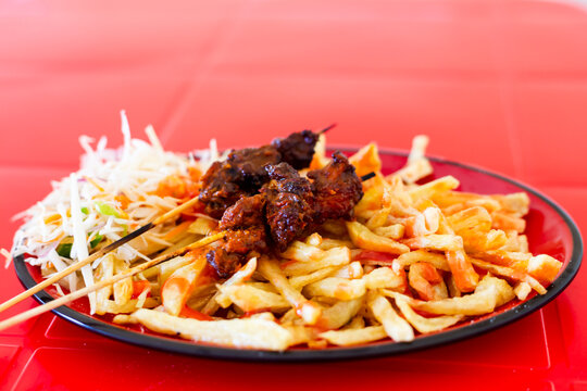 Mishikaki and Chipsi, a plate of popular Tanzanian street food combination with grilled beef skewers and french fries. Food in Tanzania