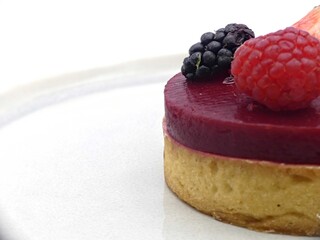 Elegant red berry tartlet topped with fresh strawberry, raspberry and blackberry © Dimitri