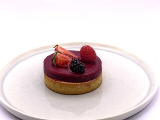 Gourmet red berry tartlet with fresh berries served on white plate © Dimitri