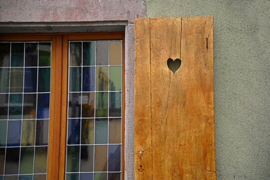 Antique rural house window with wooden shutters in Bergheim, Alsace France.