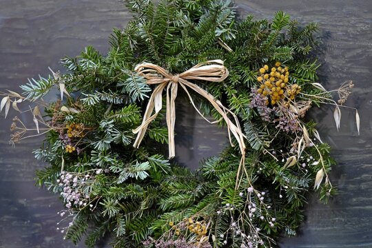 Festive handcrafted Christmas wreath on the facade of an Alsatian rural house in Bergheim, Alsace France.