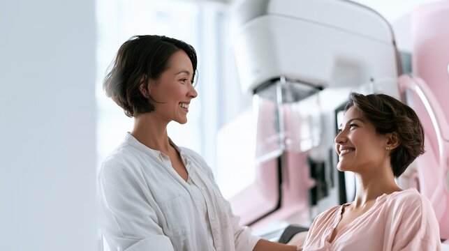 National Mammography Day: wide banner photograph of a female radiologic technologist calmly preparing a smiling woman patient beside a modern digital mammography unit