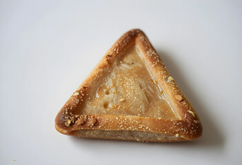 Fototapeta premium Purim celebration and Jewish holiday tradition, hamantaschen triangular cookie with poppy seed filling isolated on a clean white background