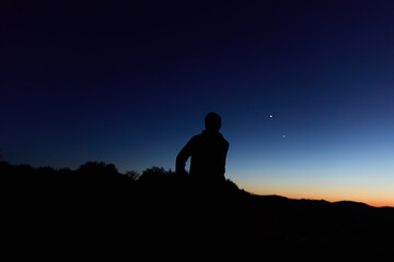 Fototapeta premium Amateur astronomer observing stars, planets, Moon and other celestial objects from a dark remote location in nature.