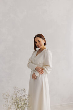 Young beautiful woman posing near white wall
