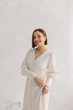 Young beautiful woman posing near white wall