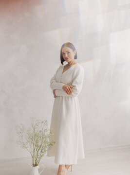 Young beautiful woman posing near white wall