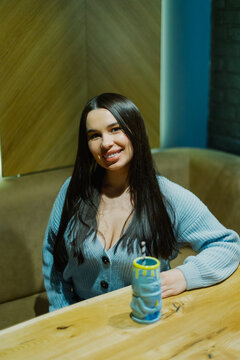 Beautiful young woman sitting at a table in a cafe